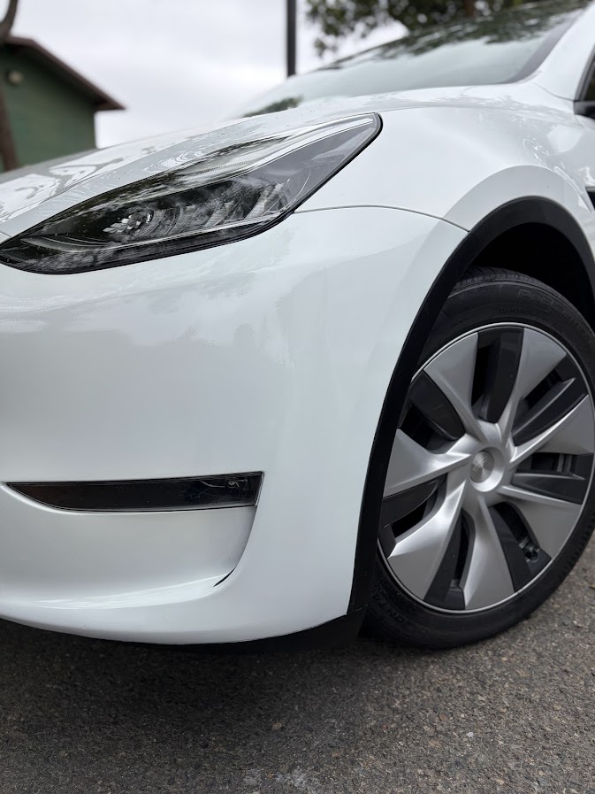 Same Tesla Model Y bumper and arch trim filled, repainted and clear-coated
