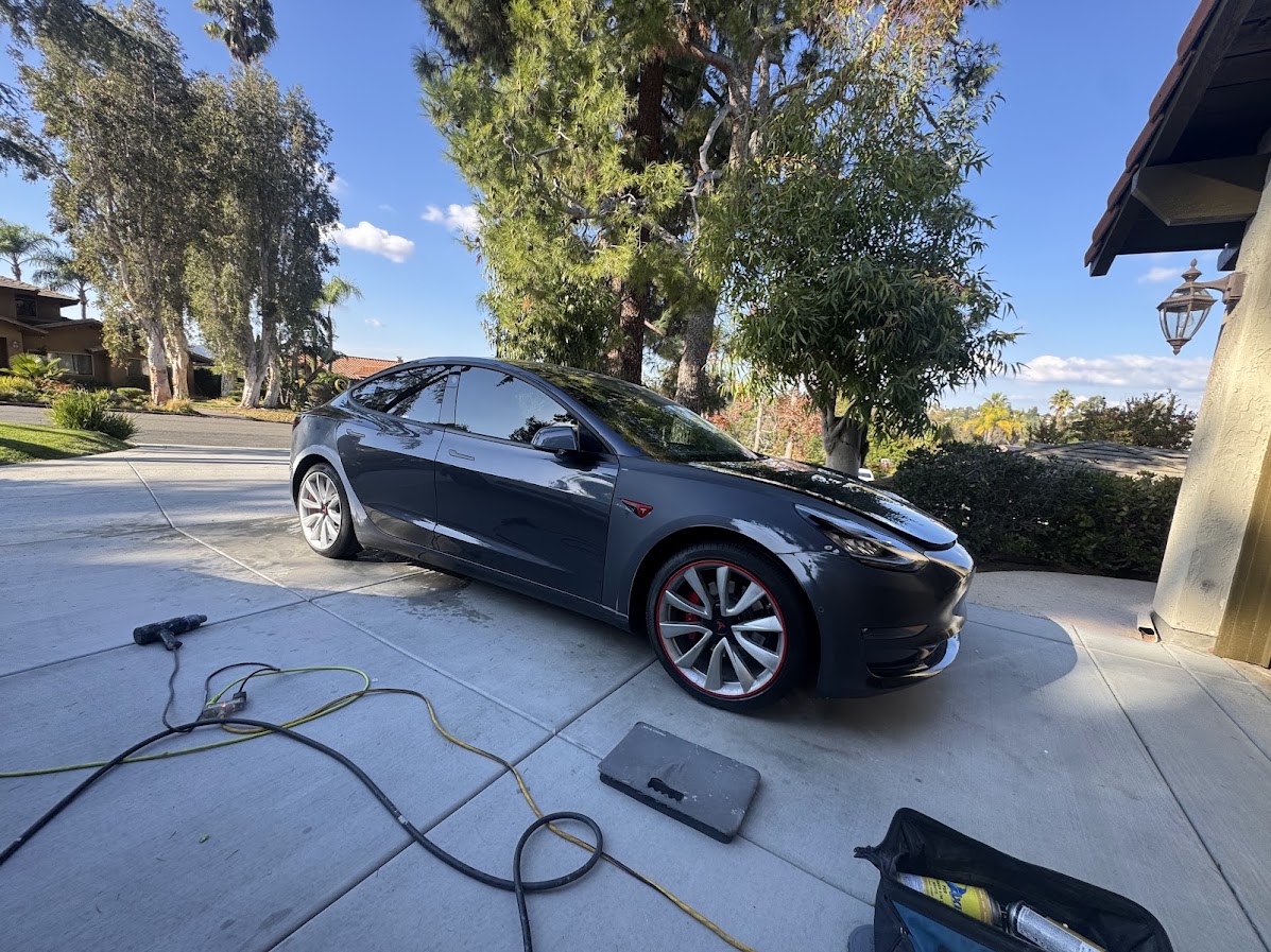 Mobile Tesla repair setup with tools laid out in a driveway
