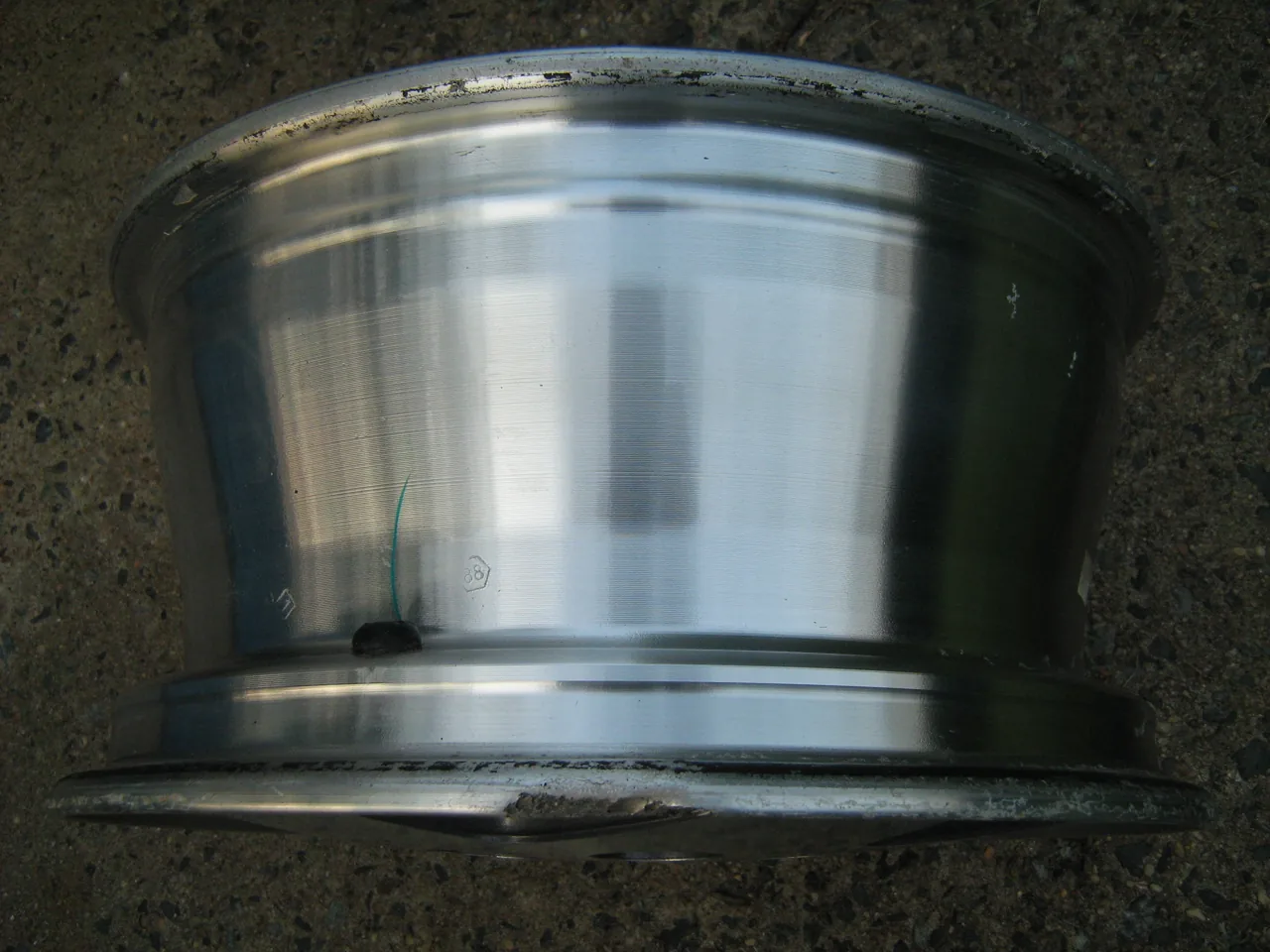 Scraped and gouged alloy wheel rim with the tire removed — example stock photo, not BumperFixers work