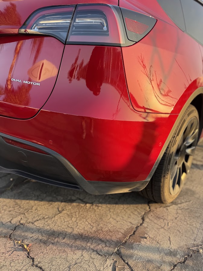 Same red Tesla Model Y rear corner repainted and clear-coated to a full gloss
