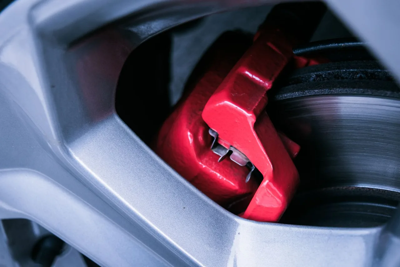 Red brake caliper visible through a silver alloy wheel, an appearance example — example stock photo, not BumperFixers work